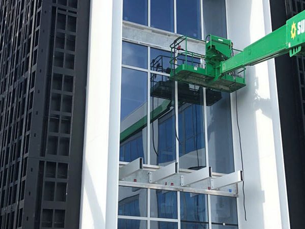 Crew installing large-scale impact glass on a commercial building in Lee County