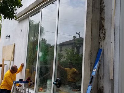 Installer replacing a window with a new hurricane-rated impact unit